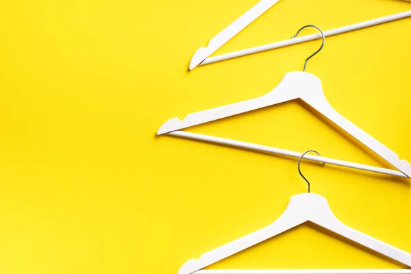 White clothes hangers on yellow background with copy space. Flat lay. Top view. Minimalism style. Creative layout. Fashion, store sale, shopping concept. Banner for feminine blog — Stock Photo, Image