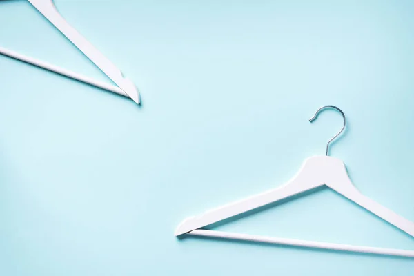 White clothes hangers on blue background with copy space. Flat lay. Top view. Minimalism style. Creative layout. Fashion, store sale, shopping concept. Banner for feminine blog — Stock Photo, Image