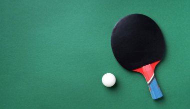 Masa tenisi raketleri ve yeşil arka planda fotokopi alanı olan beyaz top. Üst Manzara. Düz yatıyordu. Spor konsepti