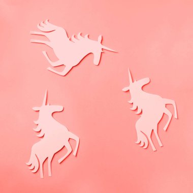 Moda mercan rengi arka planında yaratıcı tek boynuzlu at deseni. Soyut sanat dokusu Minimal fantezi konsepti. Pankart. Kare mahsul