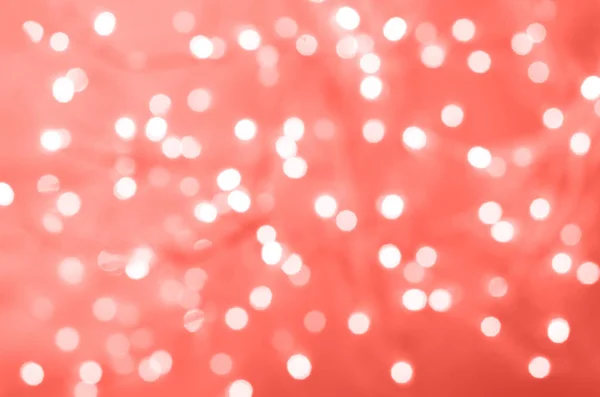 Luces navideñas brillantes festivas. Fondo de hormigón de cemento abstracto en color coral de moda. Banner borroso con bokeh . — Foto de Stock