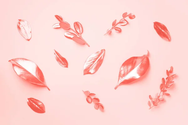 Hojas doradas sobre fondo de color coral de moda. Vista superior. Copiar espacio. Concepto de verano y otoño. Elementos creativos de diseño para invitación, tarjetas de boda, día de San Valentín, tarjetas de felicitación . —  Fotos de Stock