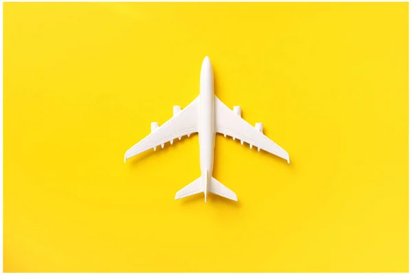 Plano branco, avião em fundo de cor amarela com espaço de cópia. Vista superior, deitado plano. Design de estilo mínimo. Viagens, conceito de férias. Banner — Fotografia de Stock