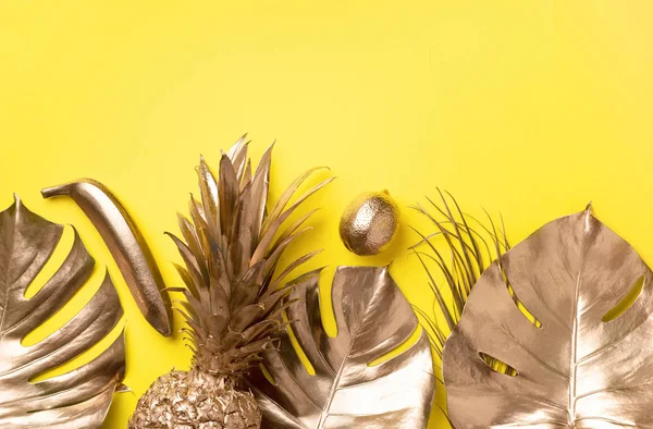 Kreatywny układ. Złoty ananas i złota palma, potwór na żółtym tle z miejsca kopiowania. Widok góry. Tropikalny płaski leżał. Egzotyczne jedzenie, szalony trend. Sztandar — Zdjęcie stockowe
