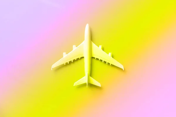 White plane, airplane in trendy neon colors. Rainbow gradient background with copy space. Top view, flat lay. Minimal style design. Travel, vacation concept. Banner. — 스톡 사진