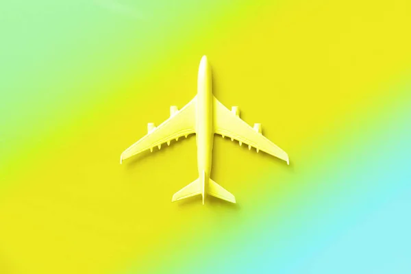 白い飛行機、流行のネオンカラーで飛行機。コピースペース付きの虹グラデーション背景。トップビュー、フラットレイアウト。ミニマルなデザイン。旅行、休暇の概念。バナー. — ストック写真