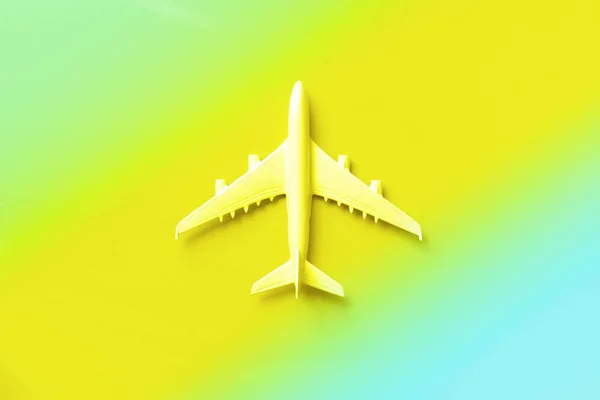 Plano blanco, avión en colores neón de moda. Fondo de gradiente de arco iris con espacio de copia. Vista superior, cama plana. Diseño de estilo mínimo. Viajes, concepto de vacaciones. Banner . —  Fotos de Stock