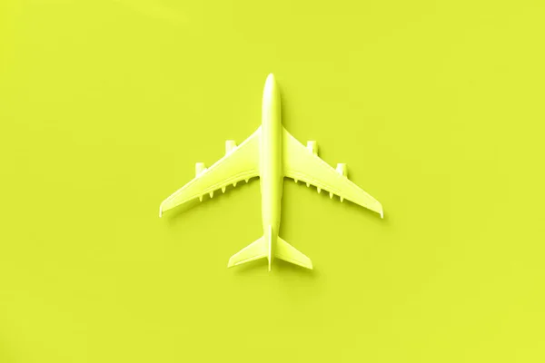 Avión blanco, avión en color amarillo neón. Fondo de gradiente de arco iris con espacio de copia. Vista superior, cama plana. Diseño de estilo mínimo. Viajes, concepto de vacaciones. Banner . — Foto de Stock