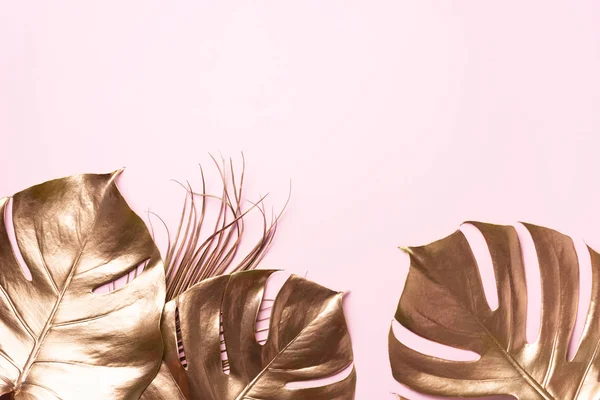 Concepto floral de estilo minimalista. Tendencia veraniega exótica. Hoja de palma monstera tropical dorada sobre fondo de color rosa pastel. Diseño brillante y brillante, concepto de moda. —  Fotos de Stock