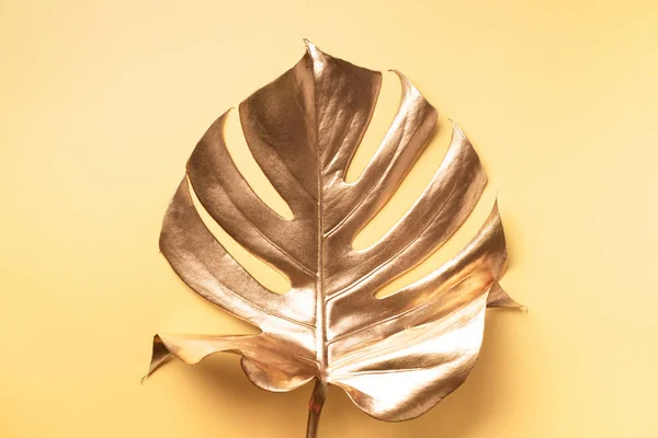 Εξωτική καλοκαιρινή τάση σε minimal στυλ. Χρυσό τροπικό φύλλο φοίνικα monstera σε παστέλ γυμνό χρώμα φόντο. Λαμπερό και λαμπερό σχεδιασμό, έννοια της μόδας. — Φωτογραφία Αρχείου