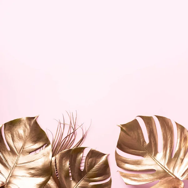 Exotisk sommar trend i minimal stil. Golden tropisk palm monstera löv på pastell rosa färg bakgrund. Glänsande och glittrig design, modekoncept. — Stockfoto