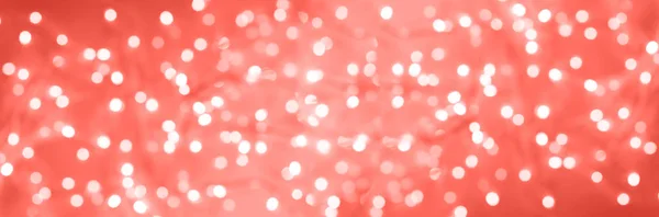 Luces navideñas brillantes festivas. Fondo de hormigón de cemento abstracto en color coral vivo de moda. Banner borroso con bokeh . — Foto de Stock