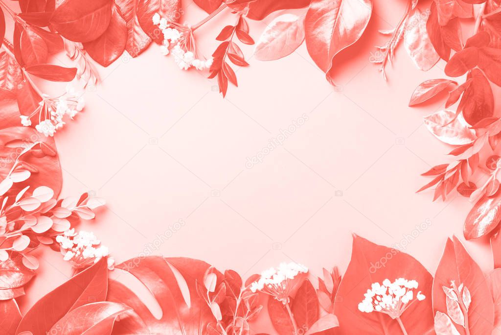Creative layout made of tropical leaves in trendy living coral color. Flat lay. Top view. Mock up