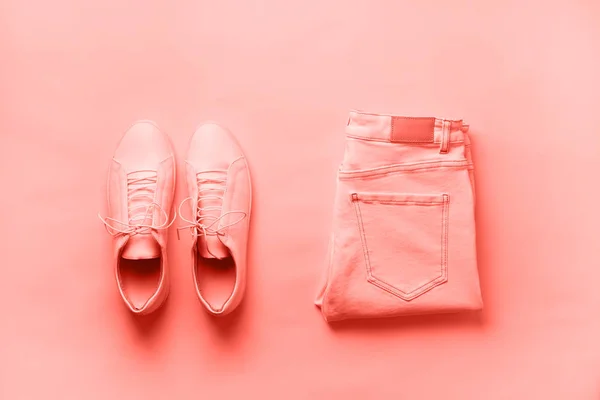 Female white sneakers and jeans, striped t-shirt on trendy coral color background with copy space. Top view. Summer fashion, capsule wardrobe concept. Creative flat lay. — Stock Photo, Image