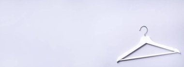 Gri arka planda, fotokopi alanı olan beyaz elbise askıları. Düz yatıyordu. Üst Manzara. Minimalizm tarzı. Yaratıcı düzen. Moda, mağaza satışı, alışveriş konsepti. Kadınsı blog için afiş