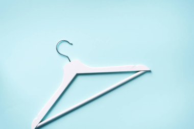 Beyaz elbise askıları mavi arka planda fotokopi alanı ile birlikte. Düz yatıyordu. Üst Manzara. Minimalizm tarzı. Yaratıcı düzen. Moda, mağaza satışı, alışveriş konsepti. Kadınsı blog için afiş