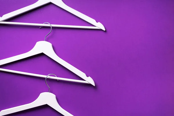 White clothes hangers on violet background with copy space. Flat lay. Top view. Minimalism style. Creative layout. Fashion, store sale, shopping concept. Banner for feminine blog — Stock Photo, Image