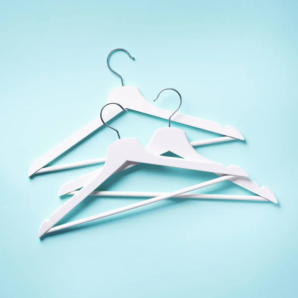 Top view of white clothes hangers on blue background with copy space. Flat lay. Minimalism style. Creative layout. Fashion, store sale, shopping concept. Banner for feminine blog — Stock Photo, Image