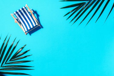 Sert gölgeli bir iskemle, arka planda palmiye yaprakları. Düz yat ve uzayı kopyala. Yaz tatili konsepti. En düşük bileşim