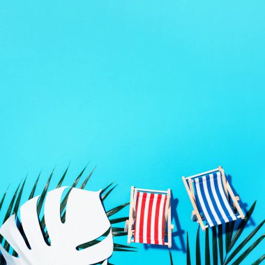 Üzerinde sert gölge, canavar ve palmiye yaprakları olan bir iskemle. Düz yat ve uzayı kopyala. Yaz tatili konsepti. En düşük bileşim