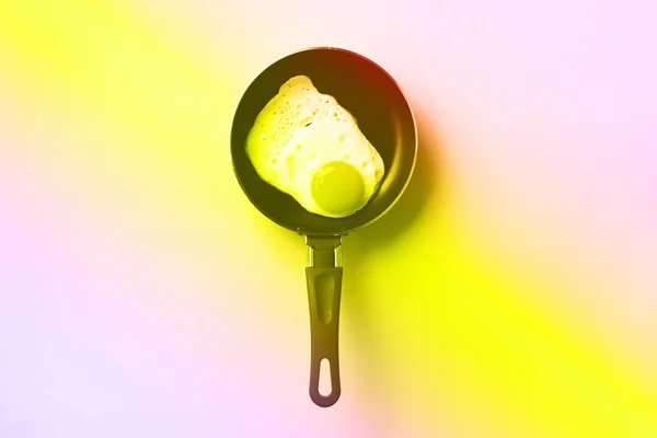 Creative food concept with fried egg on pan in trendy neon colors. Rainbow gradient background with copy space. Top view. Creative pattern in minimal style. Flat lay — 스톡 사진