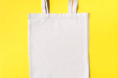 Sarı arka planda yeniden kullanılabilir tekstil torbası. Kopya alanı ile sıfır atık kavramı. Sıfır atık, plastiksiz konsept. Üst Manzara. Çevre dostu ağ tüccarı.