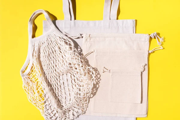 Sacs en maille et coton sur fond jaune. Style de vie durable. Concept zéro déchet. Pas de plastique . — Photo