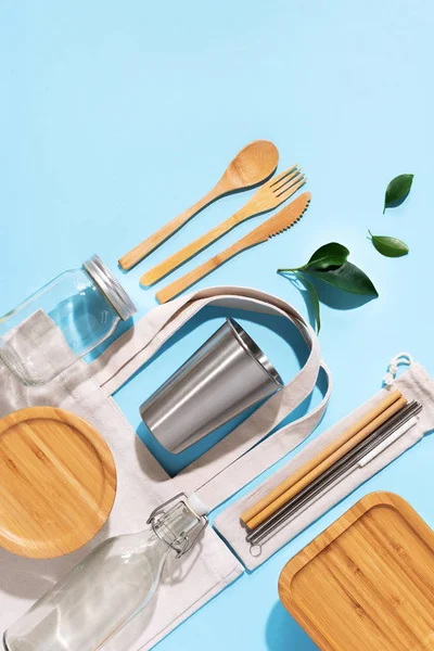 Cotton bags, glass jar, bottle, metal cup, straws for drinking, bamboo cutlery and boxes on blue background. Sustainable lifestyle. Zero waste, plastic free shopping concept — Stock Photo, Image