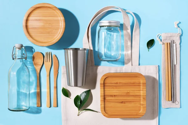 Sustainable lifestyle. Zero waste, plastic free shopping concept. Cotton bags, glass jar, bottle, metal cup, straws for drinking, bamboo cutlery and boxes on blue background — Stock Photo, Image