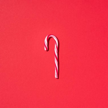 Kırmızı arka planda fotokopi alanı olan Noel şekeri kamışı. Üst Manzara. Noel ve Yeni Yıl 'da tebrik kartı. Minimum festival konsepti