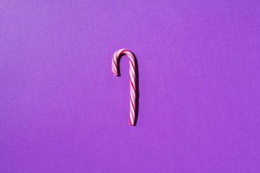 Mor arka planda fotokopi alanı olan Noel şekeri kamışı. Üst Manzara. Noel ve Yeni Yıl 'da tebrik kartı. Minimum festival konsepti