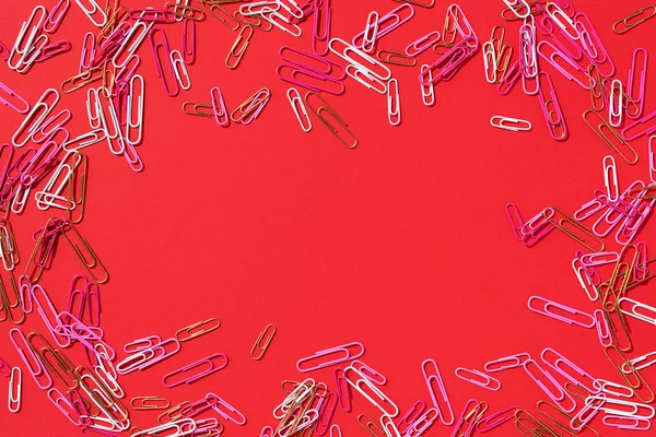 Frame of multicolored paper clips on red background. Back to school. Office, business, paperwork, education concept. Banner — 스톡 사진
