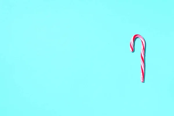 Vánoční cukrová třtina na modrém pozadí s kopírovacím prostorem. Horní pohled. Pozdrav na Vánoce a Nový rok. Minimální slavnostní koncept — Stock fotografie