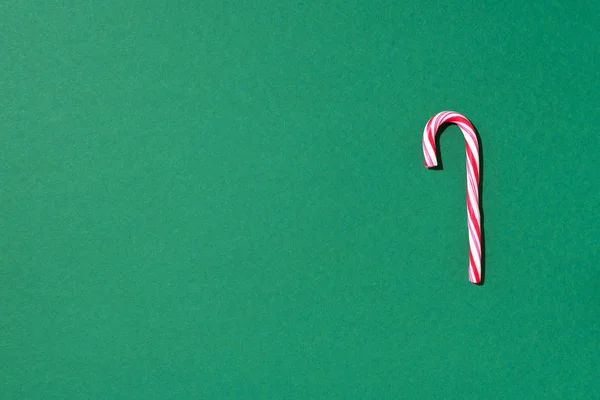 Cana de doces de Natal no fundo verde com espaço de cópia. Vista superior. Cartão de felicitações no Natal e Ano Novo. Conceito festivo mínimo — Fotografia de Stock