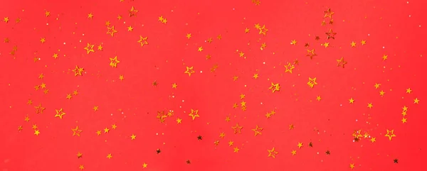 Golden star sparkles on red background. Christmas and New year concept. Festive backdrop with copy space — 스톡 사진