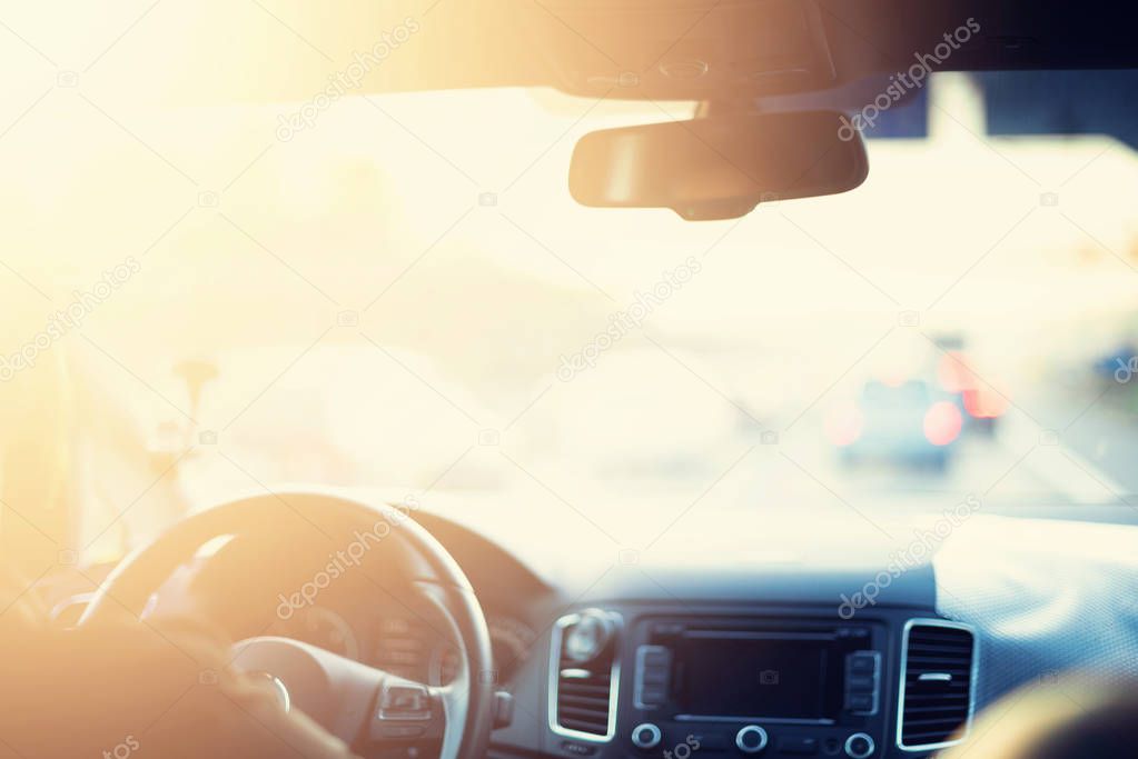 Young man driving his car. Blurred travel background with vintage toned effect, sunny bokeh. Trip, road concept. Driving test, exam