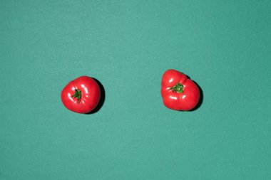 Yeşil arka planda kırmızı domates deseni. Düz yerde, üst tarafta. Yaz asgari konsepti. Vejetaryen ve vejetaryen diyeti