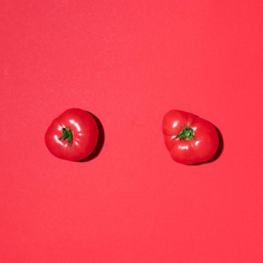 Kırmızı arka planda kırmızı domates deseni. Düz yerde, üst tarafta. Yaz asgari konsepti. Vejetaryen ve vejetaryen diyeti