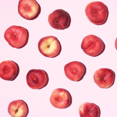 Pastel pembe arka planda şeftali deseni. Taze meyvelerden yapılmış çerçeve. Düz konum, üst görünüm, kopyalama alanı. Vejetaryen ve vejetaryen diyeti