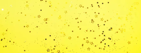 Estrela dourada brilha no fundo amarelo. Conceito de Natal e Ano Novo. Cenário festivo com espaço de cópia — Fotografia de Stock