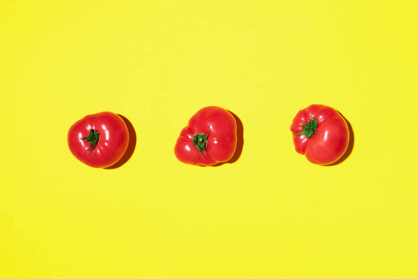 Red tomatoes pattern on yellow background. Flat lay, top view. Summer minimal concept. Vegan and vegetarian diet