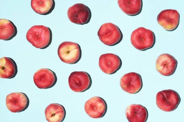 パステルブルーの背景に桃のパターン。新鮮な果物で作られたフレーム。フラットレイアウト、トップビュー、コピースペース。ビーガン・ベジタリアンダイエット — ストック写真