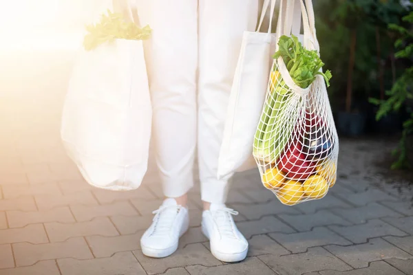 Concepto de cero residuos con espacio de copia. Mujer sosteniendo algodón shopper y bolsas de compras de malla reutilizable con verduras, productos. Comprador de malla ecológico. Cero residuos, concepto libre de plástico. — Foto de Stock