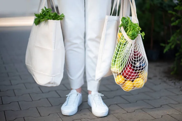 Concepto de cero residuos con espacio de copia. Mujer sosteniendo algodón shopper y bolsas de compras de malla reutilizable con verduras, productos. Comprador de malla ecológico. Cero residuos, concepto libre de plástico. — Foto de Stock