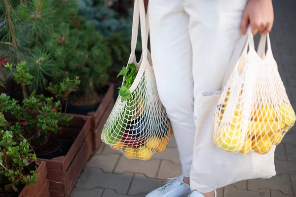 Concepto de cero residuos con espacio de copia. Mujer sosteniendo algodón shopper y bolsas de compras de malla reutilizable con verduras, productos. Comprador de malla ecológico. Cero residuos, concepto libre de plástico. —  Fotos de Stock