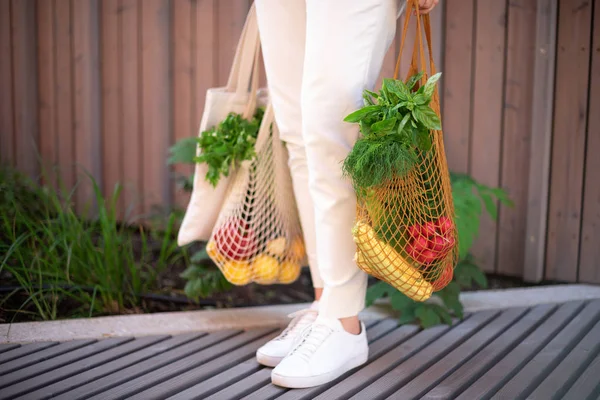 Concepto de cero residuos con espacio de copia. Mujer sosteniendo algodón shopper y bolsas de compras de malla reutilizable con verduras, productos. Comprador de malla ecológico. Cero residuos, concepto libre de plástico. —  Fotos de Stock