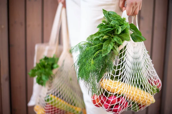 Zero waste concept with copy space. Woman holding cotton shopper and reusable mesh shopping bags with vegetables, products. Eco friendly mesh shopper. Zero waste, plastic free concept. — Stock Photo, Image