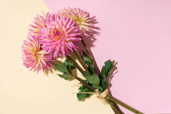 Feestelijke bloem boeket over pastel roze achtergrond, kopieer ruimte. Bovenaanzicht. Creatieve wenskaart met gele en roze dahlia bloemen — Stockfoto