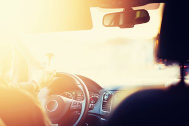 Arabasını süren genç bir adam. Bulanık seyahat arka planı, klasik tonlu efekt, güneşli bokeh. Trip, yol kavramı. Ehliyet sınavı, sınav