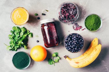 Yabanmersini, yabanmersini, arpa otu, spirulina, portakal suyu, dulse, mermer arka planda kişniş. Üst Manzara. Sağlıklı beslenme, alkali diyet, vejetaryen konsepti. Ağır metallerin içeriği detoks smoothie.